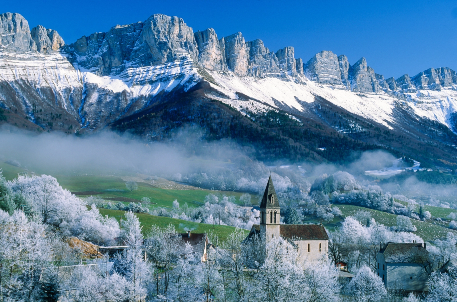 Snow-covered village and dramatic limestone cliffs of the Vercors Massif in southeastern France – an ideal alpine retreat for slow luxury and wellness seekers